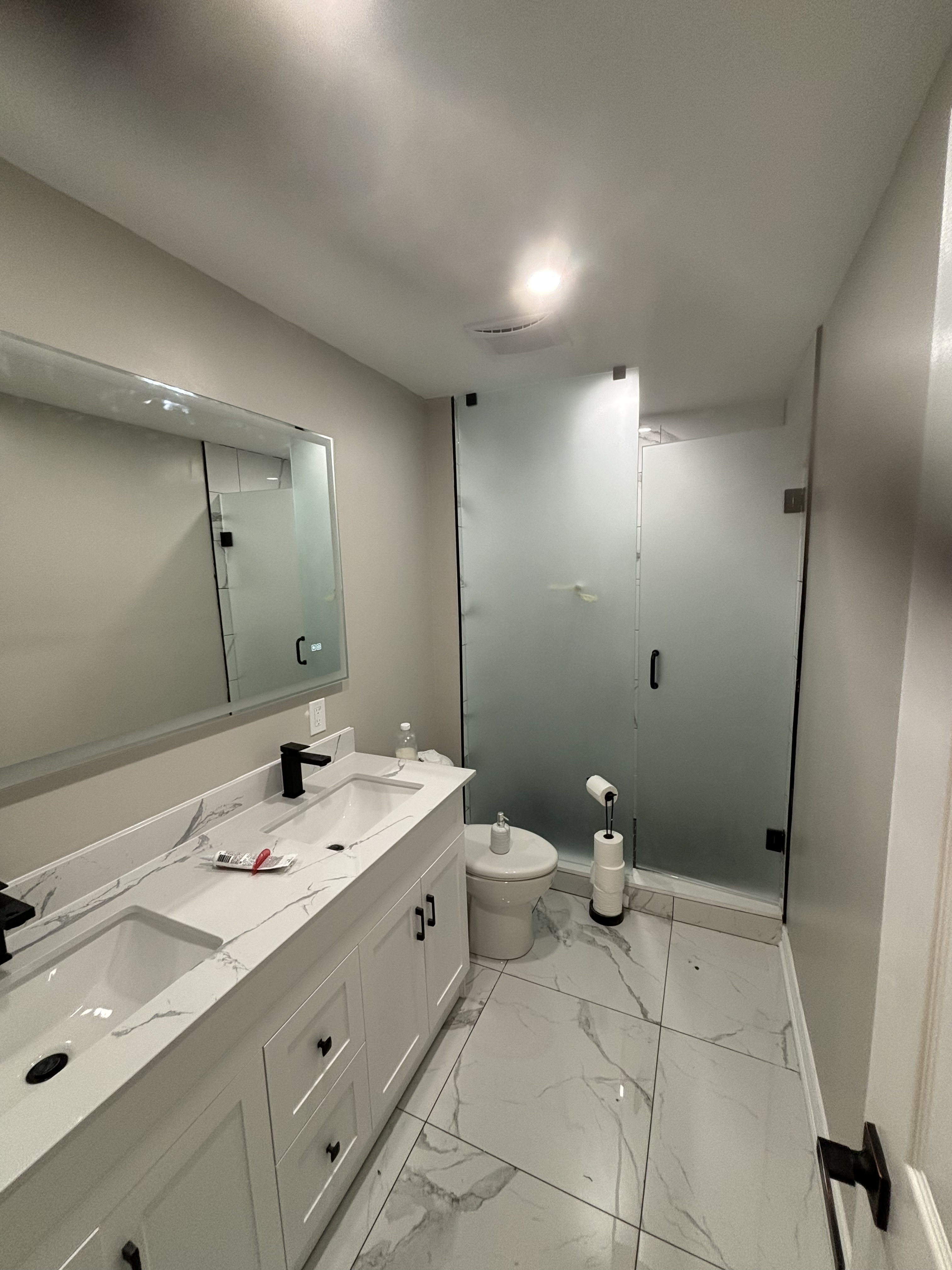 Modern tiled shower with glass door